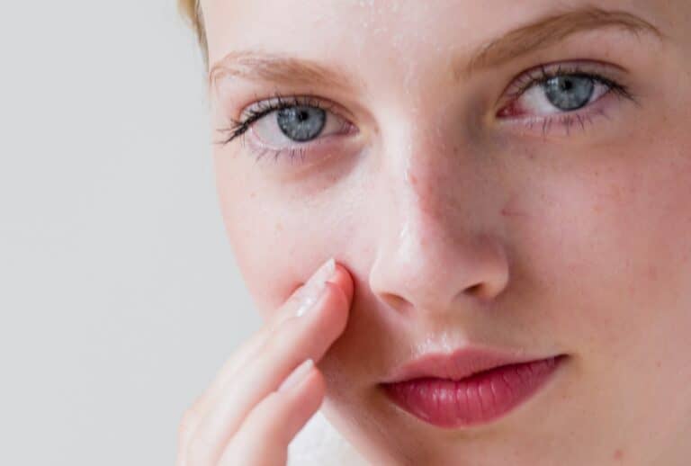 close up of woman touching face