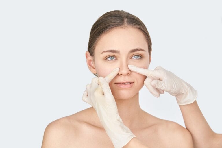 surgeon checking sides of woman's nose